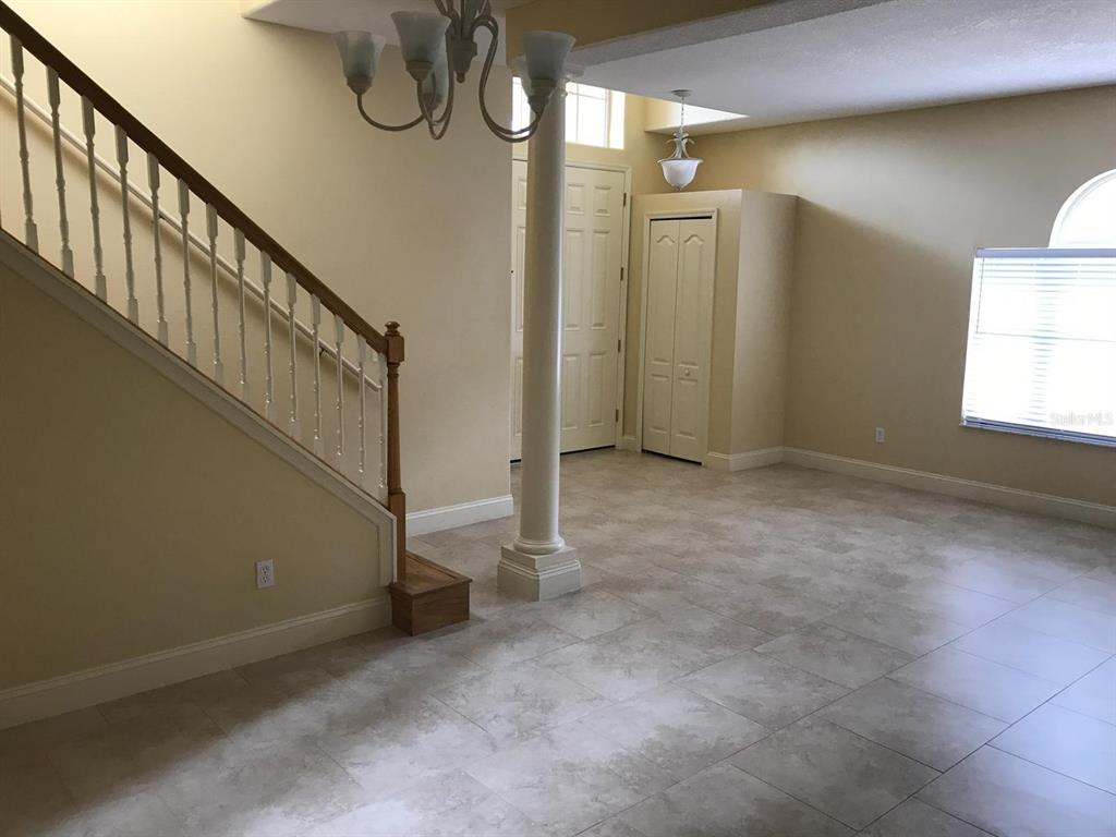 An entryway features a staircase, a central column, tile flooring, and a closet — 6628 BOUGANVILLEA CRESCENT DRIVE, ORLANDO, FL