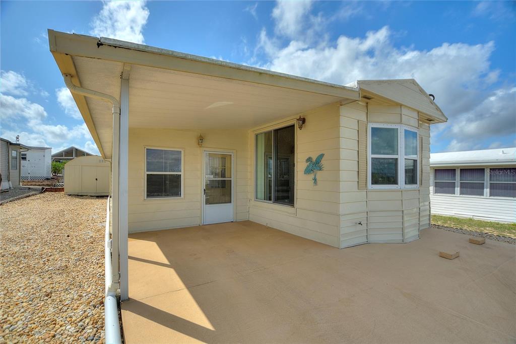 A covered patio with light-colored siding and a sliding glass door on a mobile home — 251 PATTERSON ROAD UNIT G9, HAINES CITY, FL