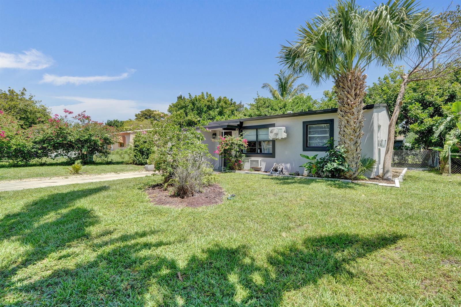 A single-story house with a palm tree in the front yard under a blue sky — 1465 NE 27th Street, Pompano Beach FL 33064, POMPANO BEACH, FL