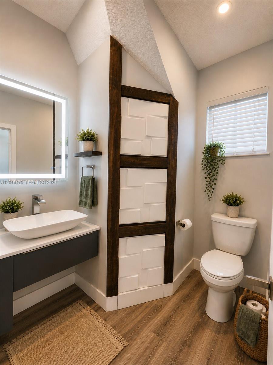A modern bathroom features a vessel sink, a textured accent wall, and wood-look flooring — 14231 SW 36th St, Miami FL 33175, MIAMI, FL