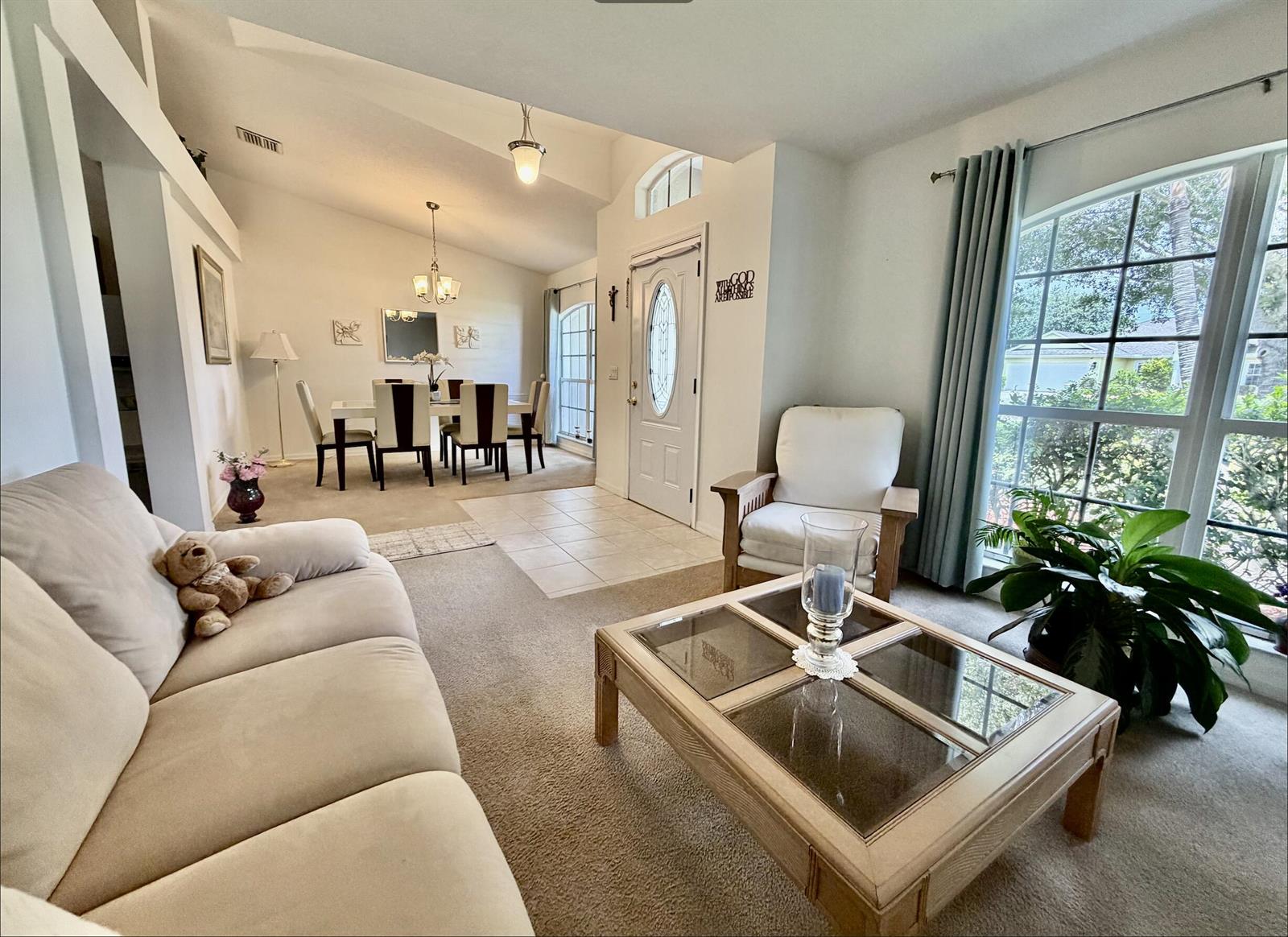 A living room with light wood flooring, a white sectional sofa, and a glass coffee table — 2906 Serenity Circle S, Fort Pierce FL 34981, FORT PIERCE, FL