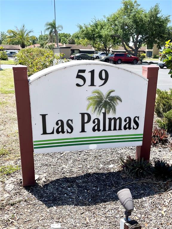 A sign for Las Palmas stands in a landscaped area with a parking lot behind — 519 ALBEE FARM ROAD UNIT 303, VENICE, FL