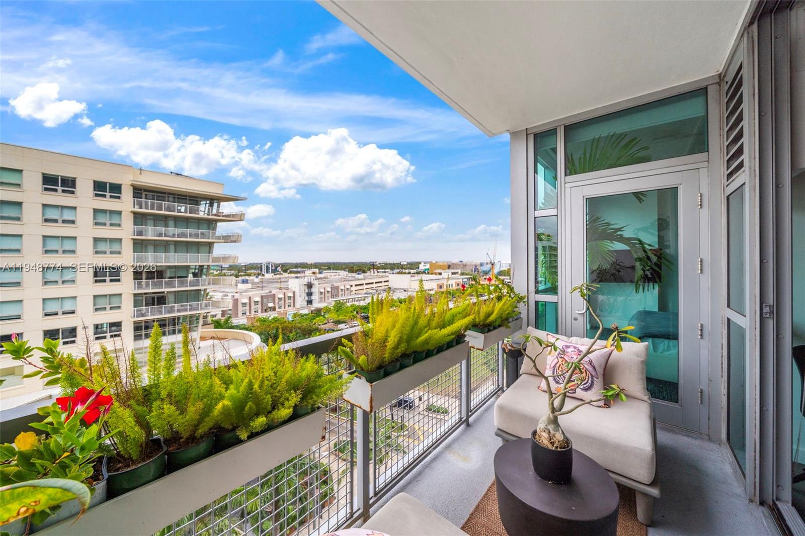 A balcony features potted plants along the railing, a lounge chair, and a city view — 3301 NE 1st Ave # H0805, Miami FL 33137, MIAMI, FL
