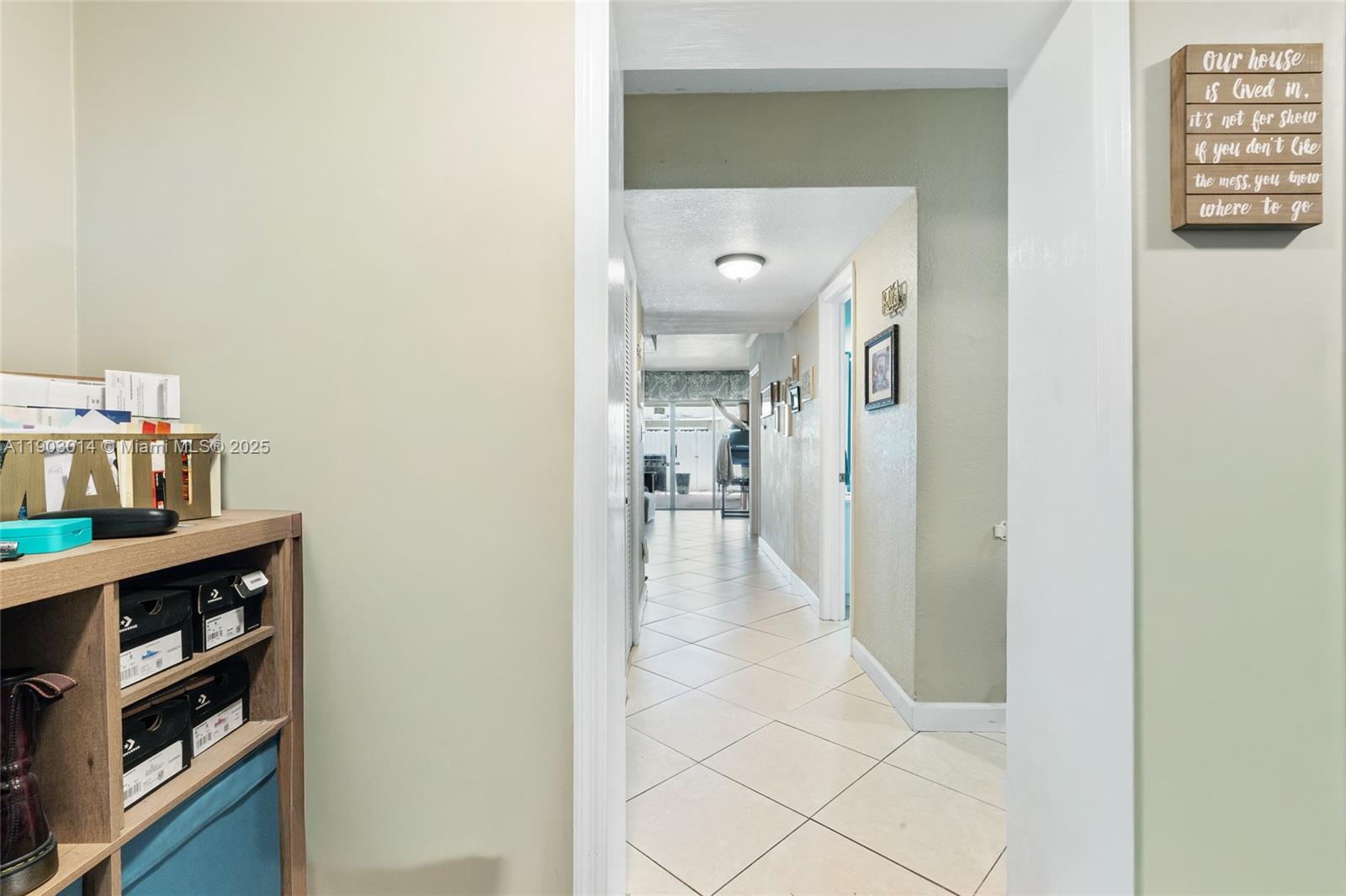 A view through a doorway into a tiled hallway with light green walls — 7144 W 2nd Ln, Hialeah FL 33014, HIALEAH, FL