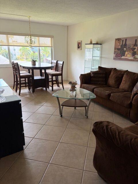A living room and dining area with tile floors, a glass table, and brown furniture — 2562 Garden Drive N # 305, FL 33461, FL