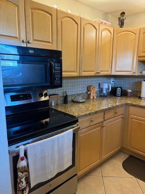 A kitchen features light wood cabinets, granite countertops, and stainless steel appliances — 2562 Garden Drive N # 305, FL 33461, FL