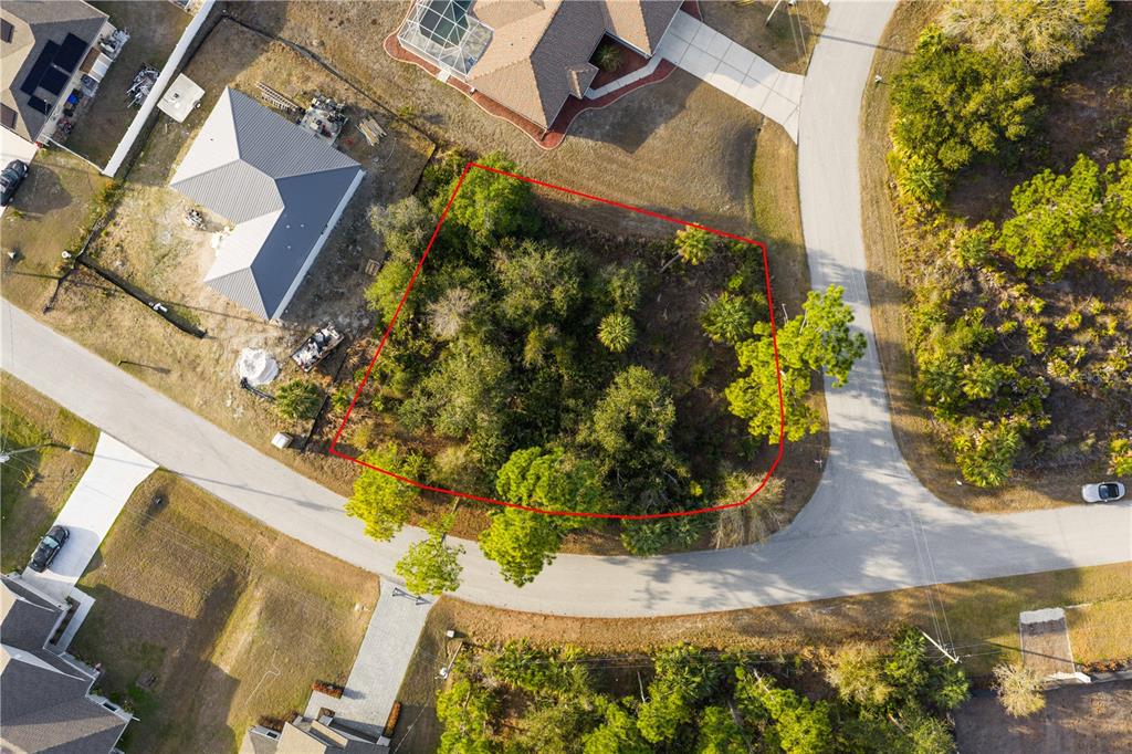 An aerial view shows a vacant, wooded residential lot outlined in red on a cul-de-sac — BECKWITH AVENUE, NORTH PORT, FL