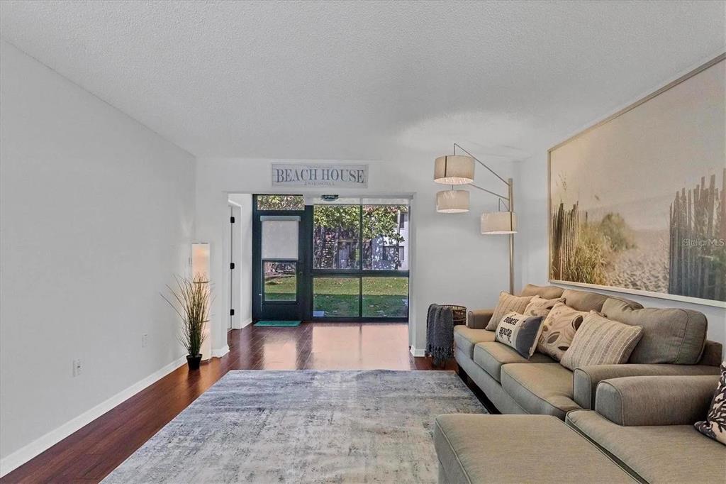 A living room features a grey sofa, a fireplace media console, and an adjacent dining area — 1640 STICKNEY POINT ROAD UNIT 40-101, SARASOTA, FL