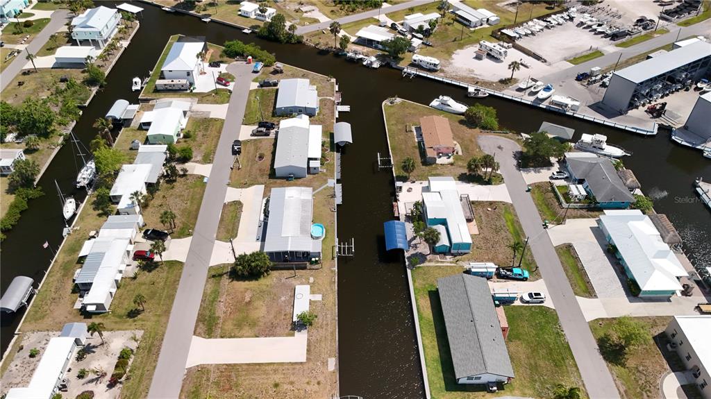 An aerial view shows several mobile homes situated along narrow canals with private boat docks — 4239 WOOD DUCK ROAD, PORT CHARLOTTE, FL