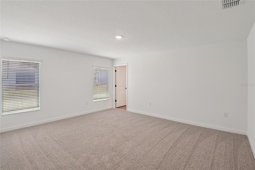 A kitchen with white cabinets, granite countertops, and an island opens to a dining area — 13331 CANADA GOOSE ROAD, WEEKI WACHEE, FL