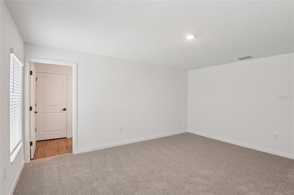 A kitchen features white cabinets, granite countertops, stainless steel appliances, and a woven area rug — 13331 CANADA GOOSE ROAD, WEEKI WACHEE, FL