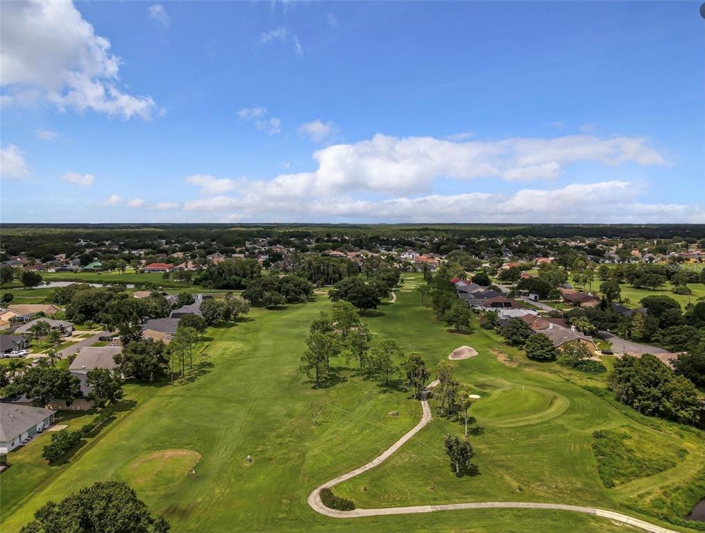 An aerial view shows a golf course fairway surrounded by residential houses and trees — DALLAS BOULEVARD, ORLANDO, FL