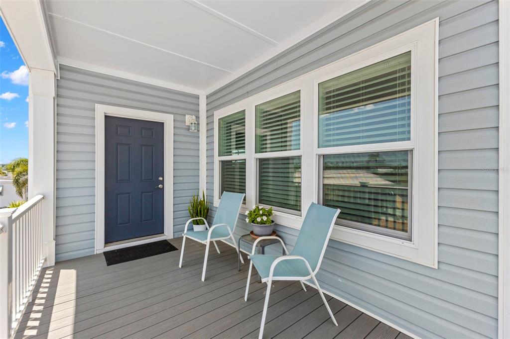 A covered porch features light blue siding, a dark blue door, and two light blue chairs — 563 MOUNT PINEY AVENUE NE UNIT 691, ST PETERSBURG, FL