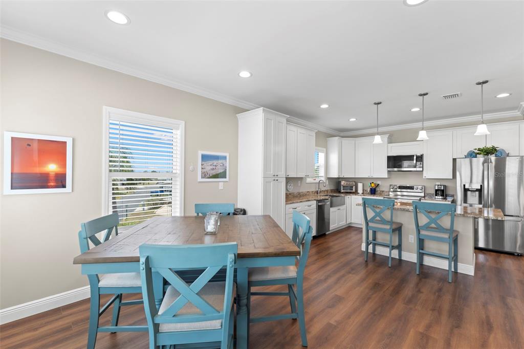 A kitchen and dining area with a wooden table, blue chairs, and white cabinetry — 563 MOUNT PINEY AVENUE NE UNIT 691, ST PETERSBURG, FL