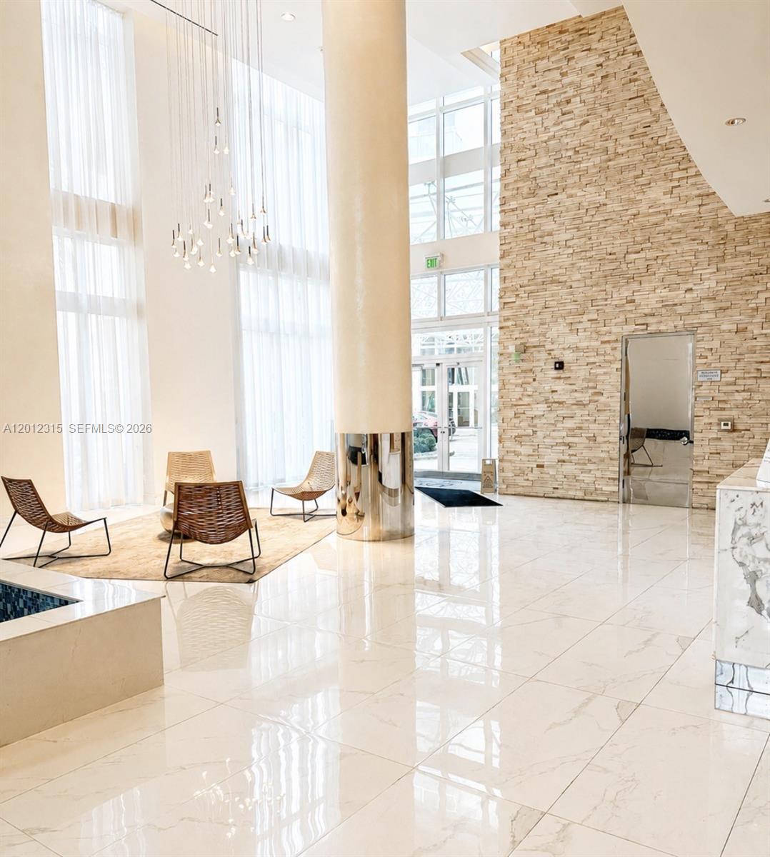 A modern lobby features a stone accent wall, marble floors, and a large central column — 41 SE 5th St # 2011, Miami FL 33131, MIAMI, FL