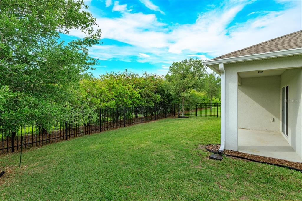 A kitchen with dark wood cabinets and a granite island overlooks a carpeted living area — 3075 GIBRALTAR BOULEVARD, NEW SMYRNA BEACH, FL