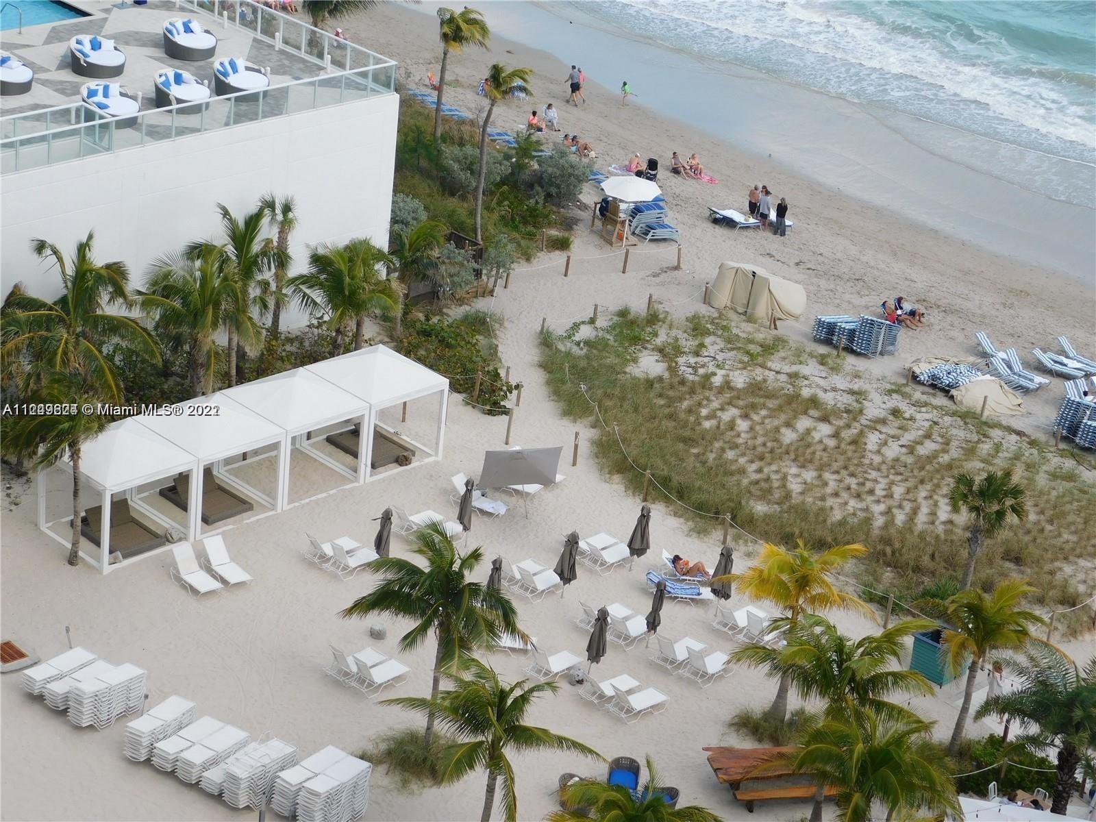 An elevated view shows a beach with white cabanas, lounge chairs, and palm trees — 4111 S Ocean Dr # 1004, Hollywood FL 33019, HOLLYWOOD, FL