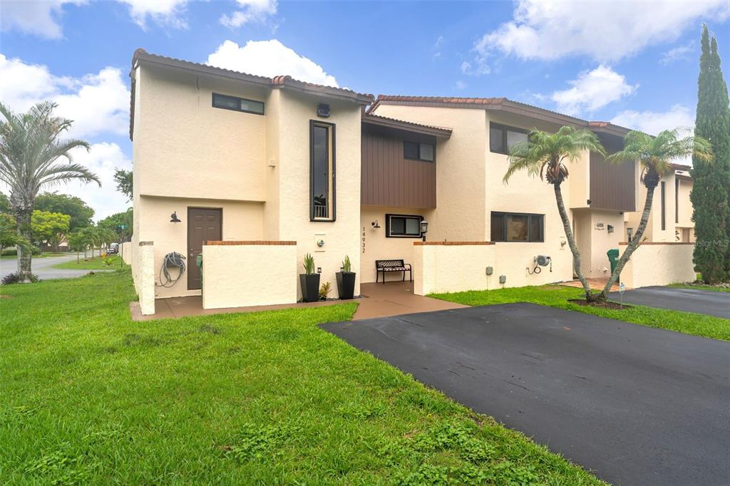A two-story townhouse with beige stucco walls, brown trim, and a paved driveway — 14932 SW 89TH ST, MIAMI, FL