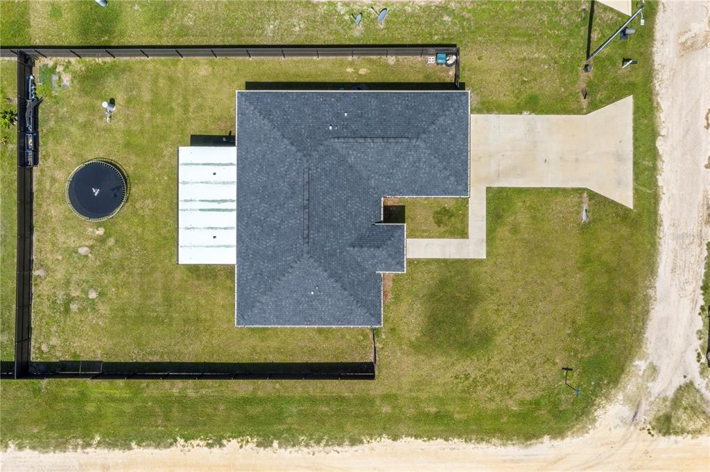 An aerial view shows a house with a dark roof, a backyard trampoline, and a driveway — 13210 SW 112TH PLACE, DUNNELLON, FL