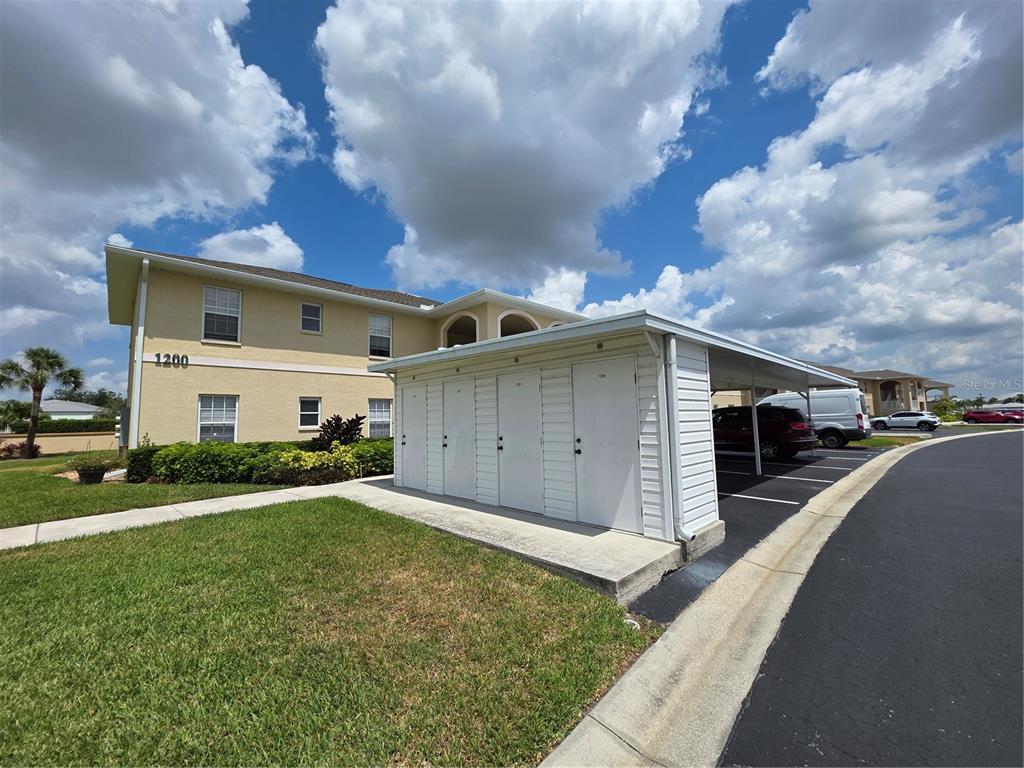 A two-story apartment building with a covered parking area and exterior storage units — 5800 SABAL TRACE DRIVE UNIT 1201, NORTH PORT, FL