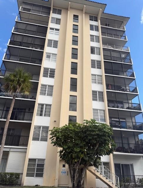 A multi-story apartment building features stacked balconies with dark screens and a central stairwell — 4164 Inverrary Dr # 913, Lauderhill FL 33319, LAUDERHILL, FL