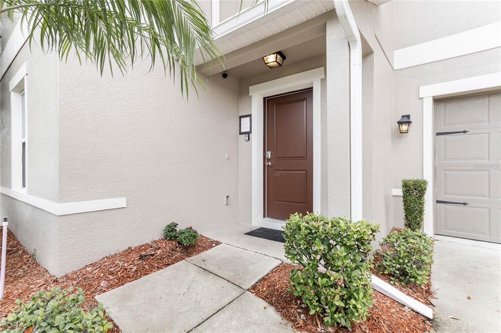 The exterior entrance features a brown front door, a concrete walkway, and a small garage — 4740 BLUE DIAMOND STREET, KISSIMMEE, FL