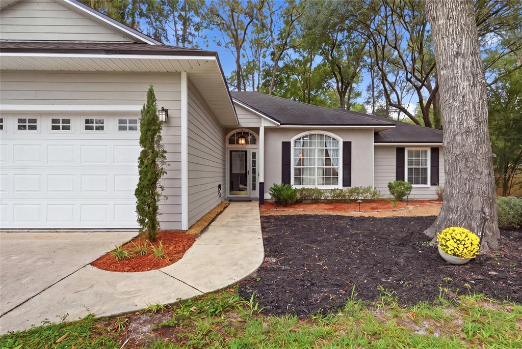 A single-story house with gray siding, a white garage door, and a concrete walkway — 5840 SW 85TH STREET, GAINESVILLE, FL