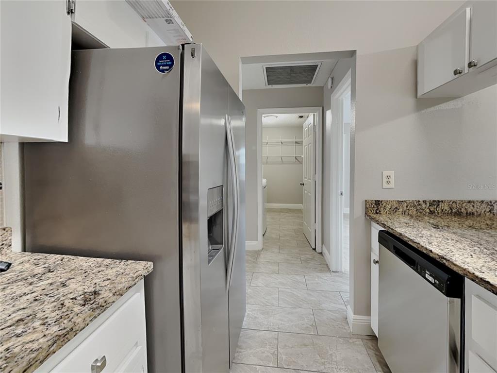 A kitchen features stainless steel appliances, granite countertops, white cabinets, and a tiled floor — 488 NORTHVIEW STREET, PORT CHARLOTTE, FL