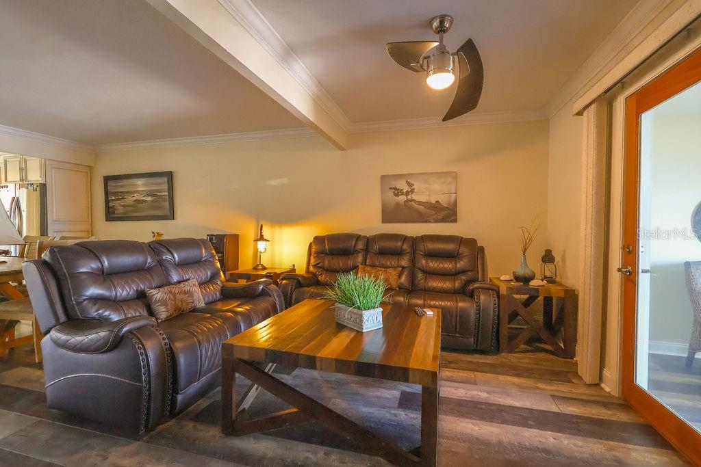 A living room features two brown leather sofas, a wooden coffee table, and a ceiling fan — 11001 SE SUNSET HARBOR ROAD UNIT B10, SUMMERFIELD, FL