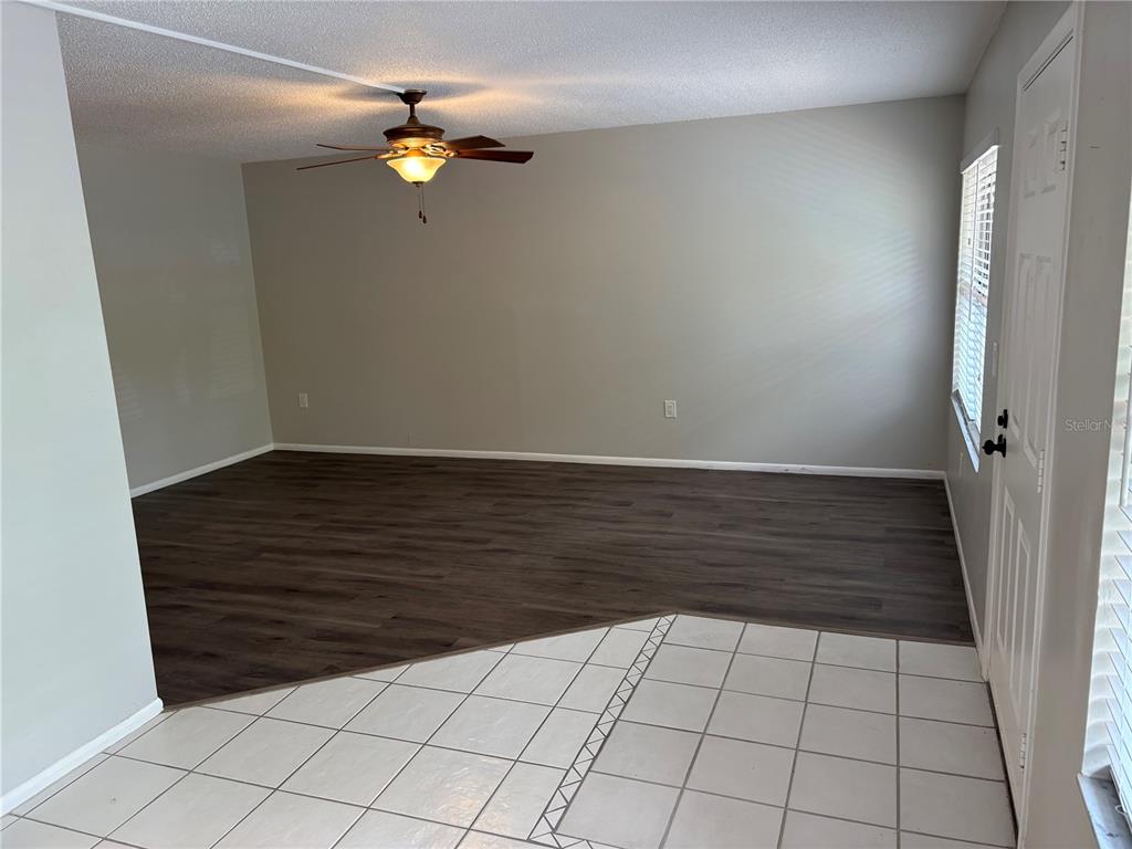 An interior view showing a living area with dark wood-look flooring and a tiled entryway — 515 30TH AVENUE W UNIT H108, BRADENTON, FL