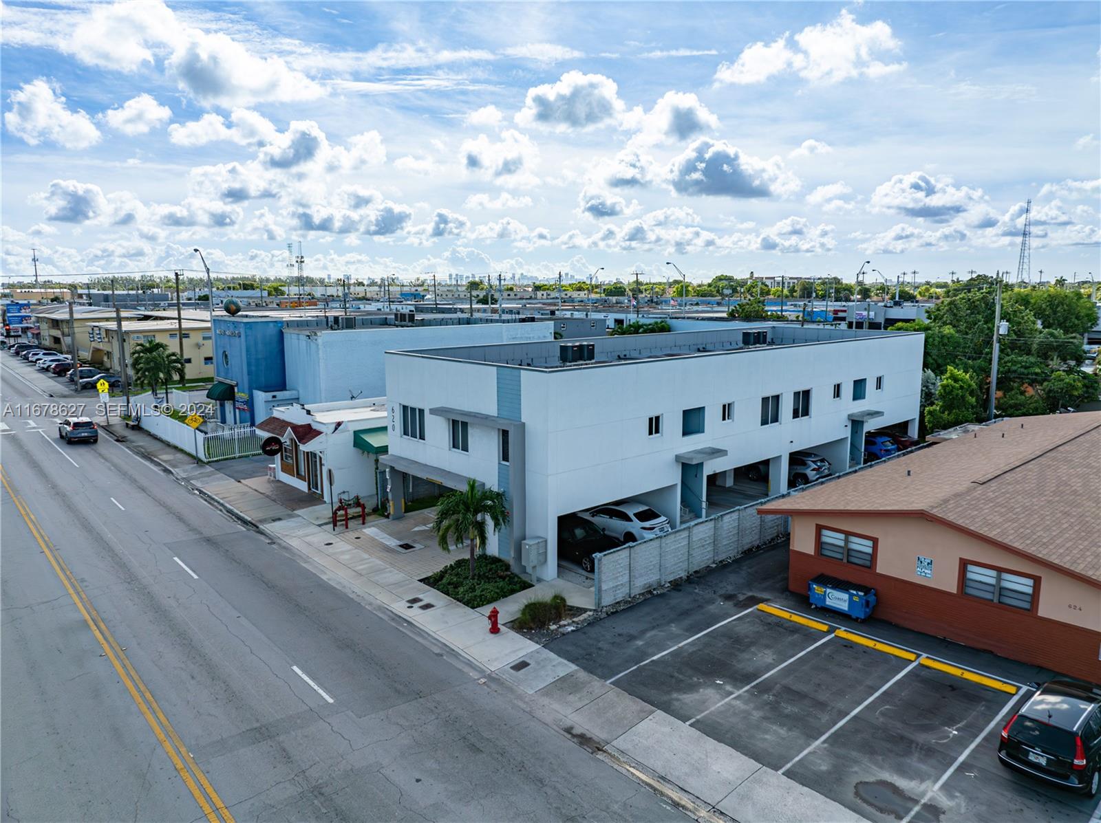 An aerial view shows a white two-story commercial building with ground-level parking next to a road — 620 W 29th St, Hialeah FL 33012, HIALEAH, FL
