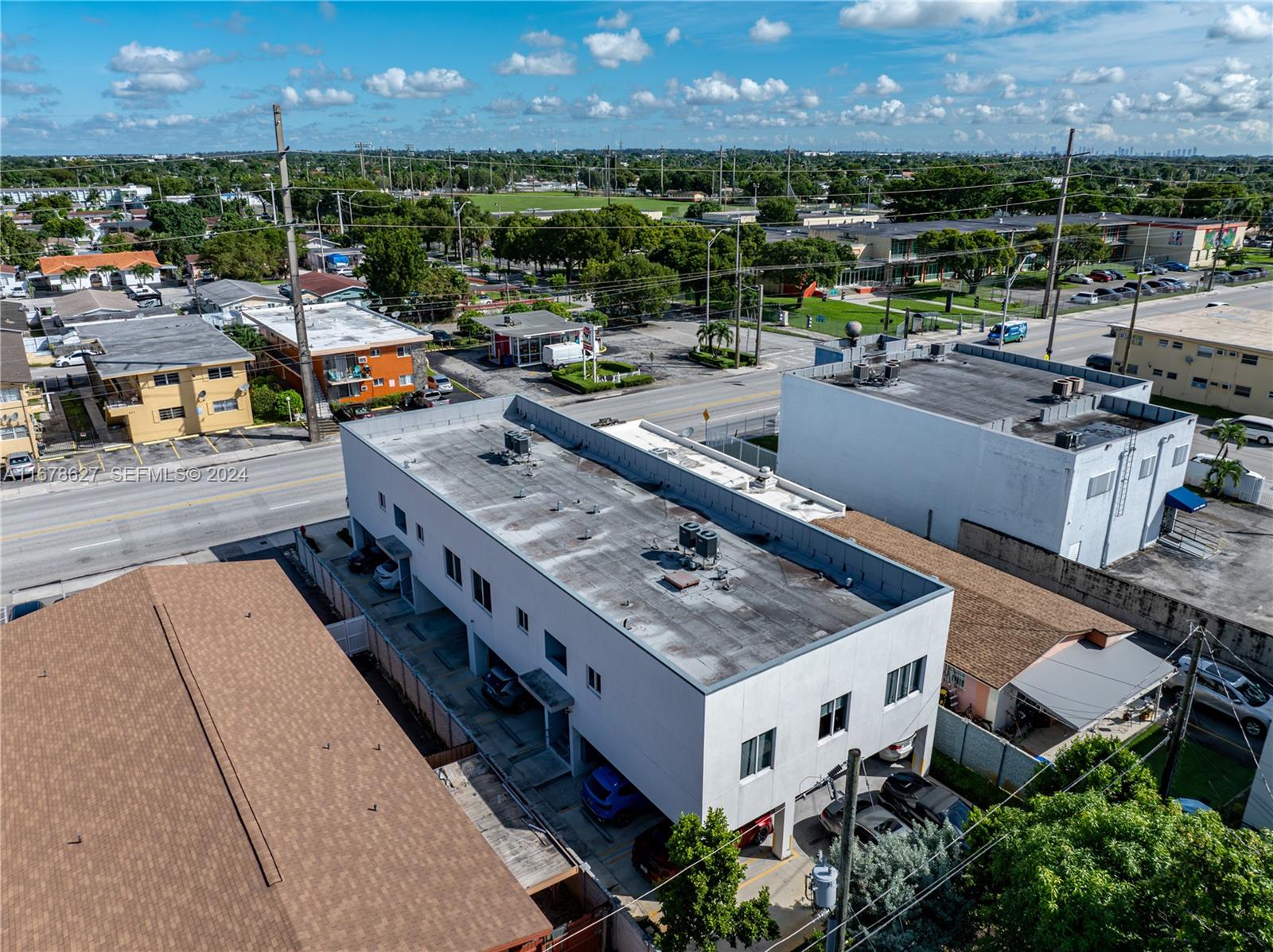 An aerial view shows a multi-story white building with covered parking next to a street — 620 W 29th St, Hialeah FL 33012, HIALEAH, FL