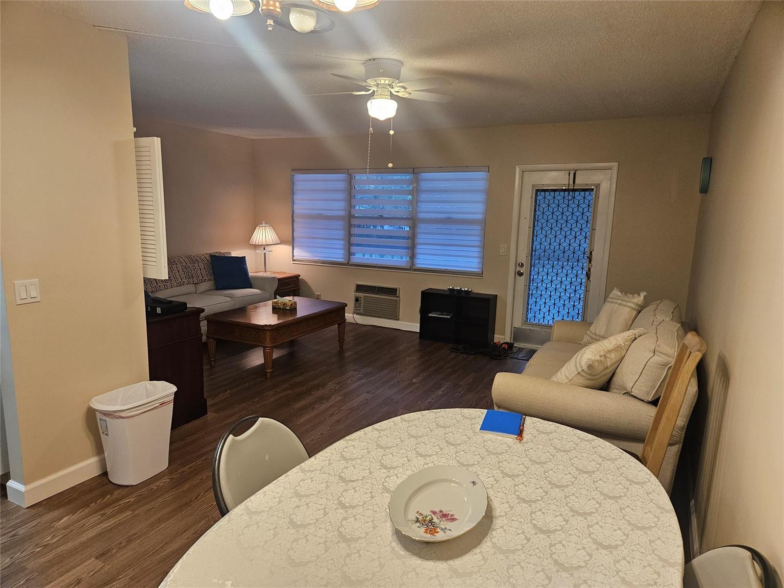 A living room and dining area feature wood-look flooring, a ceiling fan, and two sofas — 82 Tilford D # 82, Deerfield Beach FL 33442, DEERFIELD BEACH, FL