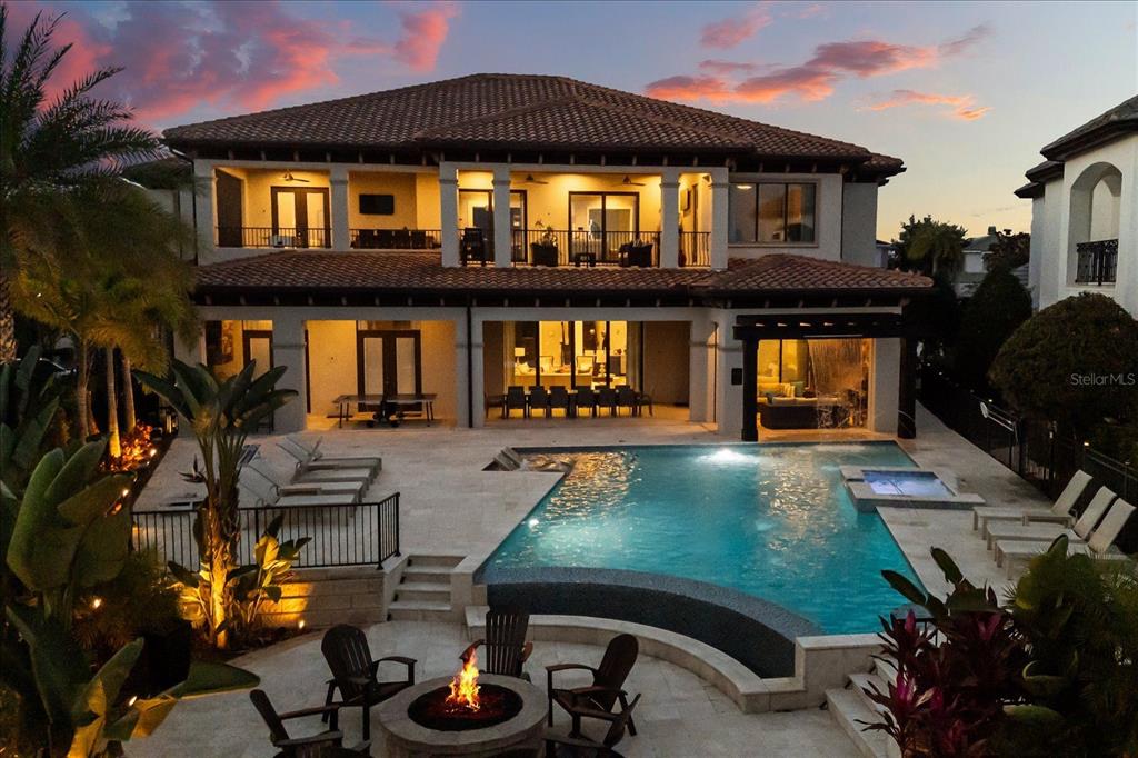 A two-story house with a tiled roof, swimming pool, fire pit, and covered patio area — 7840 PALMILLA COURT, REUNION, FL
