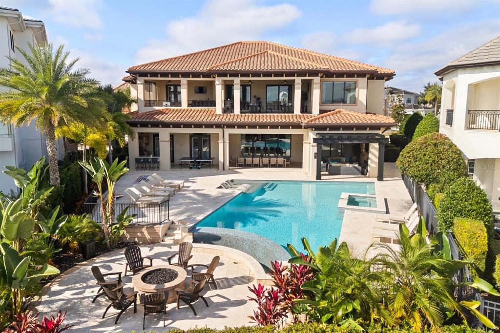 A two-story house features a swimming pool, spa, and fire pit in the backyard — 7840 PALMILLA COURT, REUNION, FL