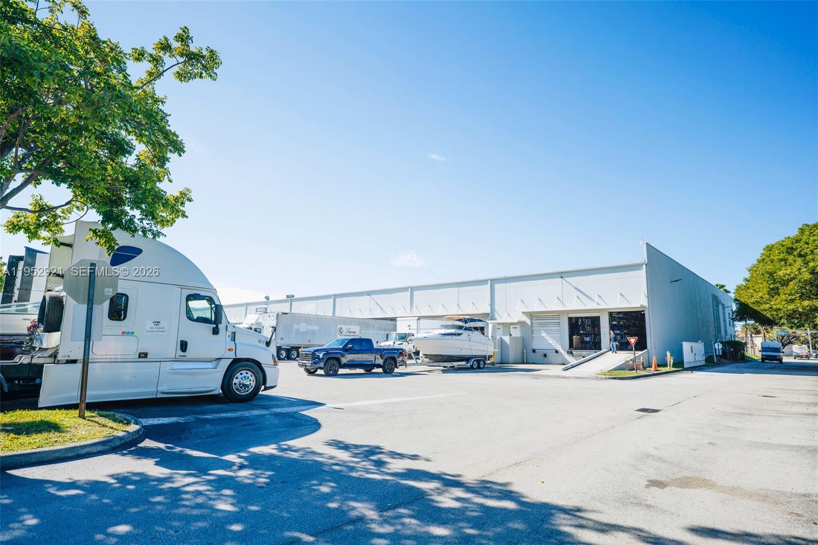 A white industrial warehouse building features loading docks, a parked semi-truck, and a boat trailer — 7865 NW 46th St # 8, Doral FL 33166, DORAL, FL