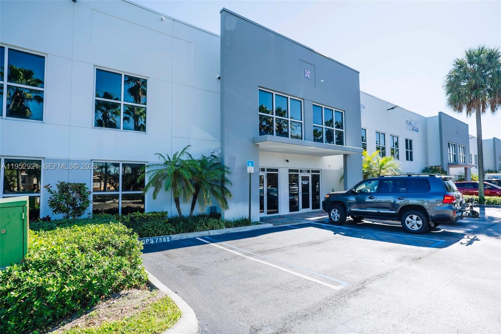 This is an exterior view of a commercial building with a parking lot in front — 7865 NW 46th St # 8, Doral FL 33166, DORAL, FL