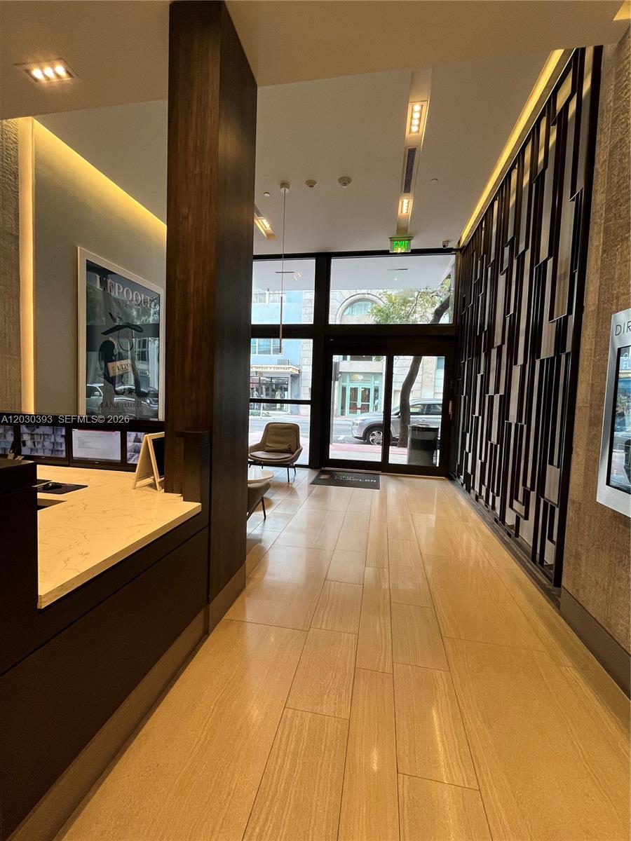 A modern lobby features a reception desk, tiled floors, and glass doors leading to the street — 14 NE 1st Ave # 1210, Miami FL 33132, MIAMI, FL