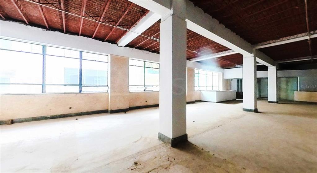 An open-plan commercial space features exposed brick ceilings, concrete columns, and large windows — 201 TETUAN STREET, SAN JUAN, PR