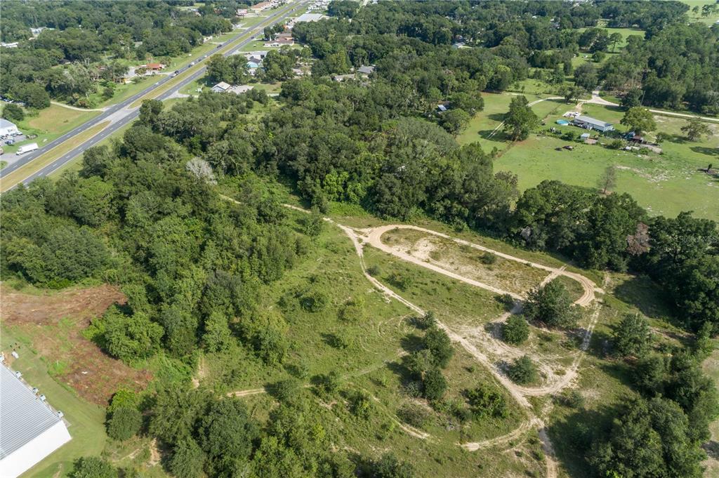 Aerial view of a grassy lot with dirt paths forming a distinct shape — 7711 SE 126TH PLACE, BELLEVIEW, FL