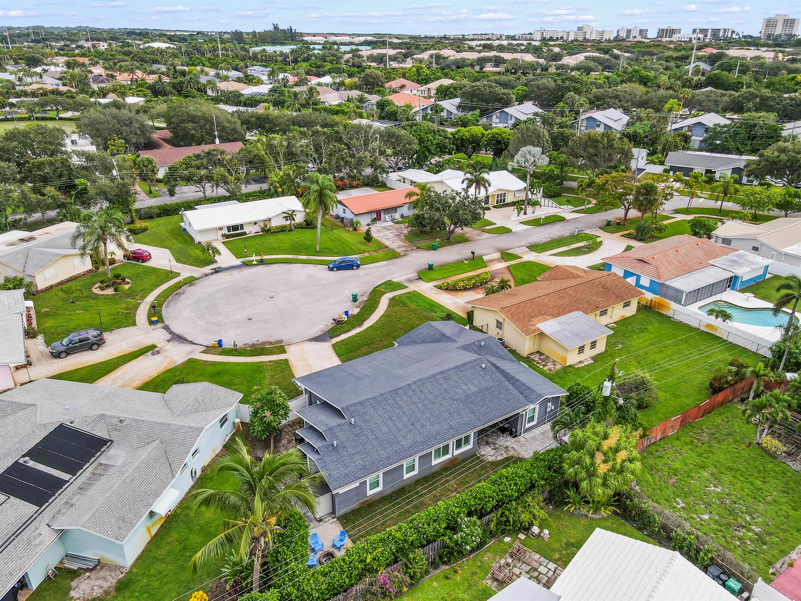 An aerial view shows a suburban neighborhood with houses, a cul-de-sac, and green lawns — 68 Azalea Circle, Jupiter FL 33469, JUPITER, FL