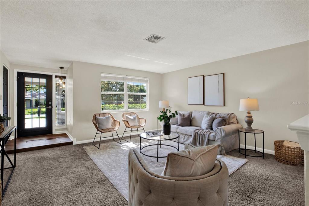 A living room features gray carpeting, a sofa, two rattan chairs, and a front door — 10898 119TH STREET N, SEMINOLE, FL