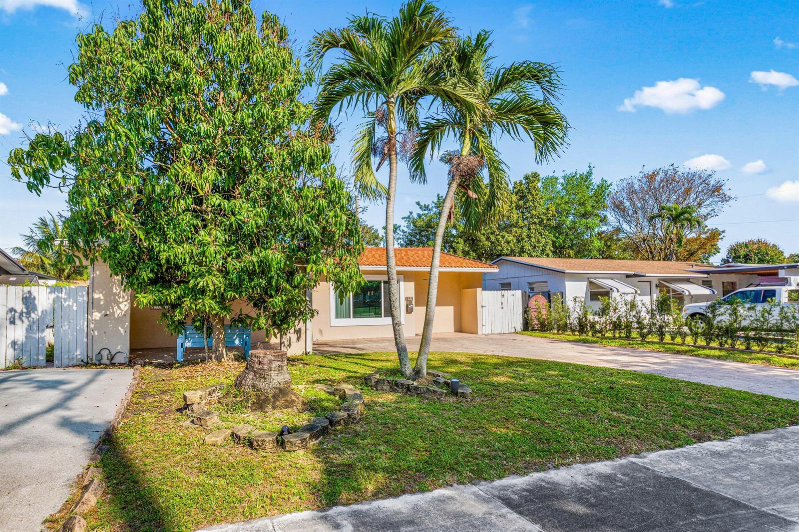 A single-story house with a palm tree, a large tree, and a paved driveway — 1121 N 66th Terrace, Hollywood FL 33024, HOLLYWOOD, FL