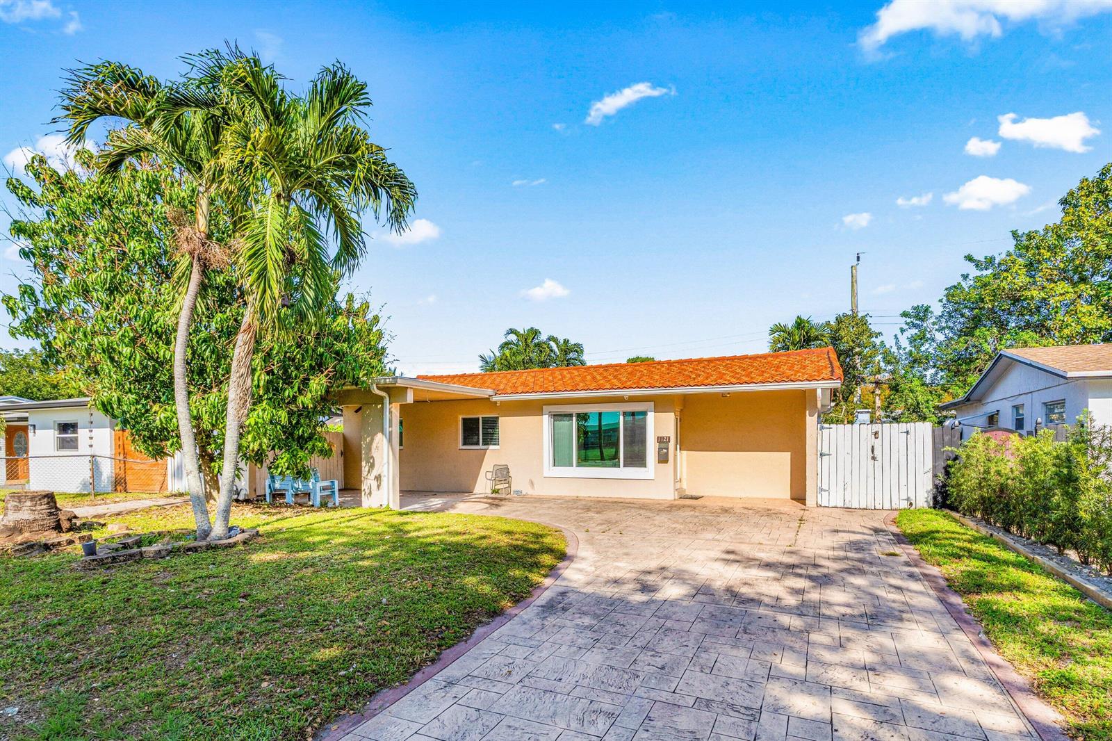 A single-story house with a tiled roof, a paved driveway, and a palm tree — 1121 N 66th Terrace, Hollywood FL 33024, HOLLYWOOD, FL