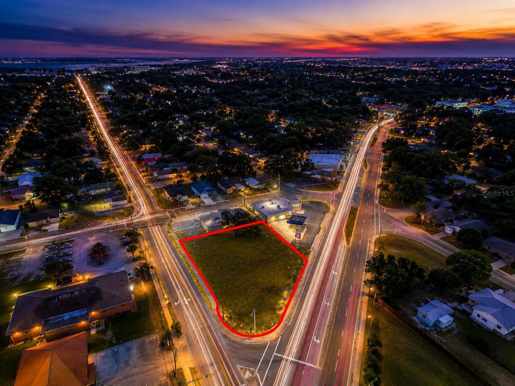 An aerial view shows a vacant, triangular-shaped lot outlined in red at a street intersection — 0 10TH STREET W, LAKELAND, FL