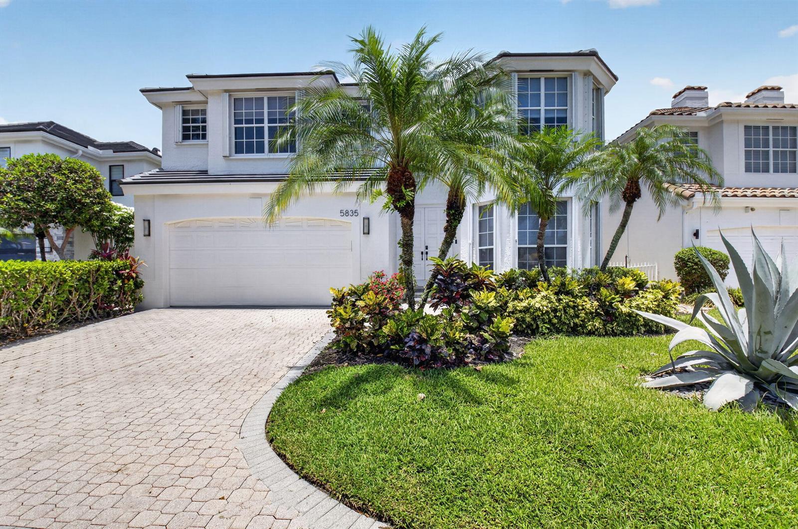 A two-story white house features a paved driveway, palm trees, and a landscaped front yard — 5835 NW 42nd Terrace, Boca Raton FL 33496, BOCA RATON, FL