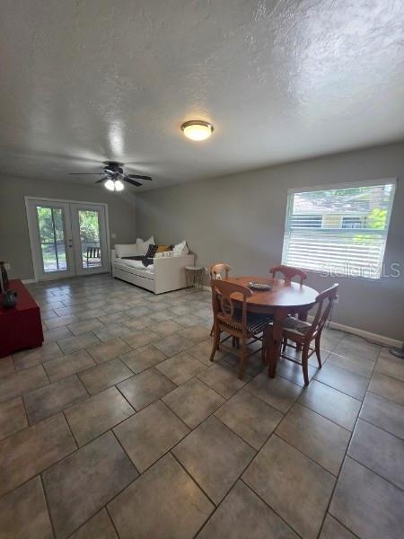 A dining area with tile floors and a ceiling fan opens to a living space — 4643 SUMMERWIND DRIVE UNIT 22, SARASOTA, FL