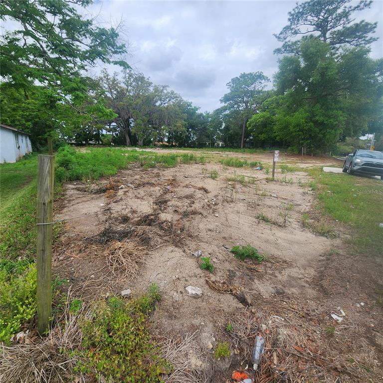 A vacant, sandy residential lot with scattered vegetation and a wooden fence post — 1648 CLARCONA ROAD, APOPKA, FL
