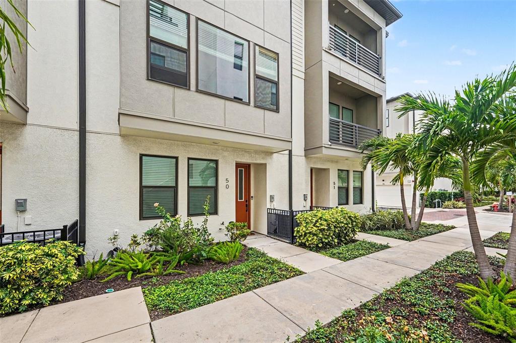 The exterior of a modern multi-story townhouse with a brown front door and landscaping — 2511 N GRADY AVENUE UNIT 50, TAMPA, FL