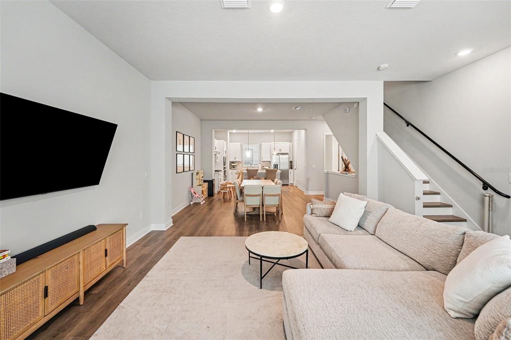 A living room with a sectional sofa and television opens into a dining area and kitchen — 2511 N GRADY AVENUE UNIT 50, TAMPA, FL